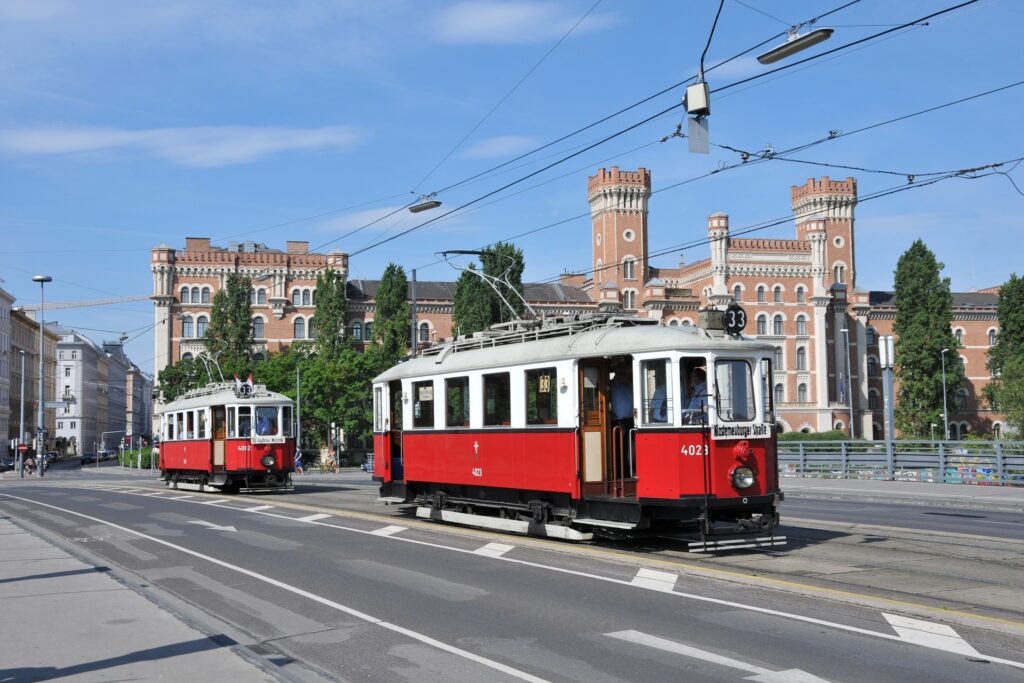 Vor der prächtigen Kulisse der Rossauer Kaserne überqueren der M 4023 gefolgt vom M 4082 der Wiener Linien, betafelt als Linie 33 die Augartenbrücke (Foto: Roman Lillich)