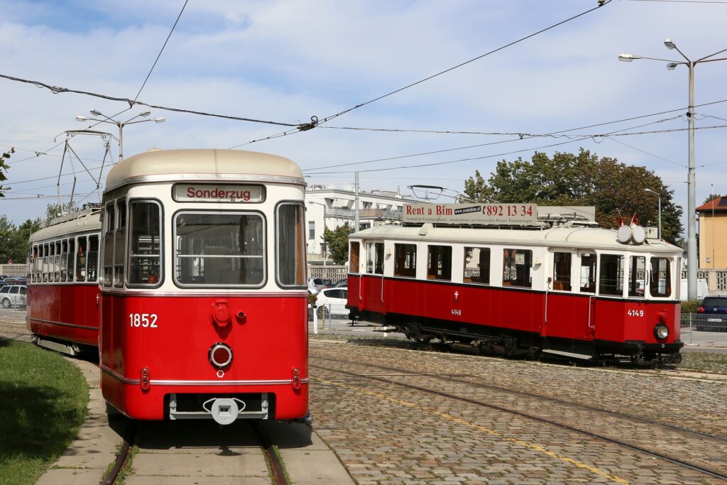 Freud und Leid im Juni 2015 in der Hauptwerkstätte der Wiener Linien: links der fertiggestellte 1852 auf Bremsprobefahrt und rechts der auf zwei Achsbruchwagen aufgebockte 4149 (Fotos: Christian Peschl)